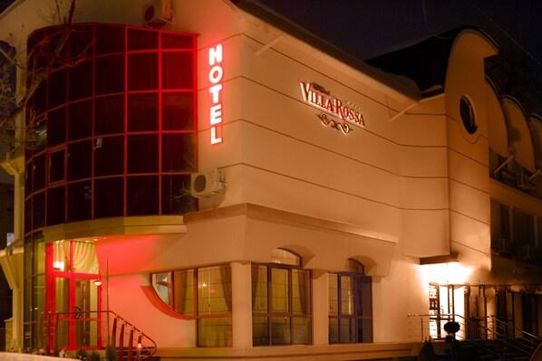 A hotel with a prominent 'HOTEL' sign and 'VILLA ROSSA' branding. It features a modern architectural design with large windows and a distinctive red-lit section. - Villa Rossa (Chisinau)