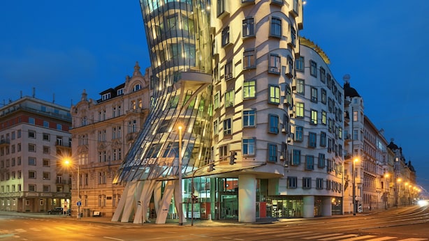 A modern building with a unique curved facade and a glass structure. - Dancing House hotel - Tančící dům (Prague)