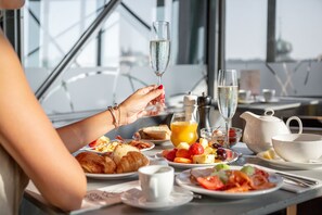A breakfast table with croissants, fruit, and a glass of champagne. - Dancing House hotel - Tančící dům (Prague)