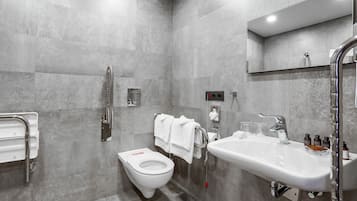 Ein modernes Badezimmer mit Toilette, Waschbecken und Dusche.