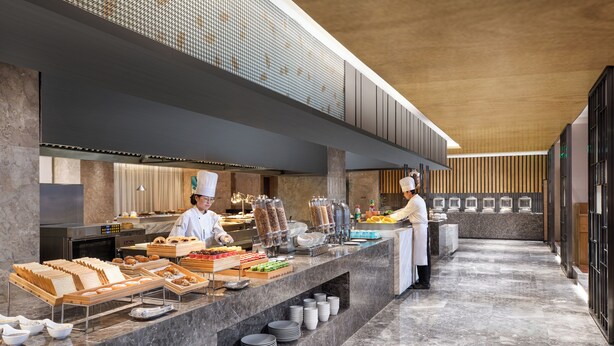 Un moderno montaje de buffet con una barra de mármol, alimentos ordenados y un diseño limpio y contemporáneo.