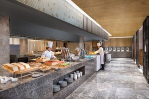 Un moderno montaje de buffet con una barra de mármol, alimentos ordenados y un diseño limpio y contemporáneo.