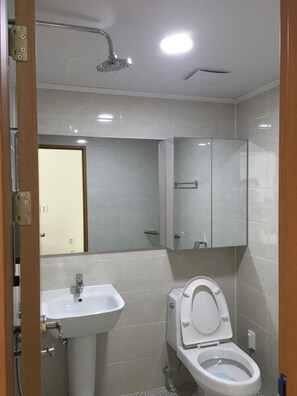 Un baño con lavamanos blanco, inodoro y ducha.