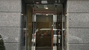 La entrada al edificio Golden Dragon, con una puerta de cristal y un picaporte de metal.