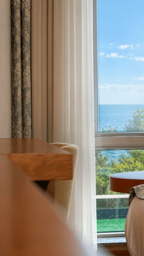 A room with a view of the sea through a window, a wooden table, and a chair. - Yildiz Life Hotel (Trabzon)