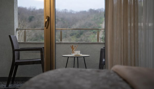 Un balcón con mesa y sillas, vistas al exterior y una puerta.