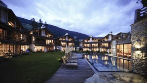 Un complexe hôtelier comprenant plusieurs bâtiments en bois, une terrasse en bois et une piscine.