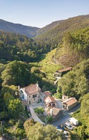 Uma propriedade rural com uma casa grande, vinhedo e uma estrada sinuosa.