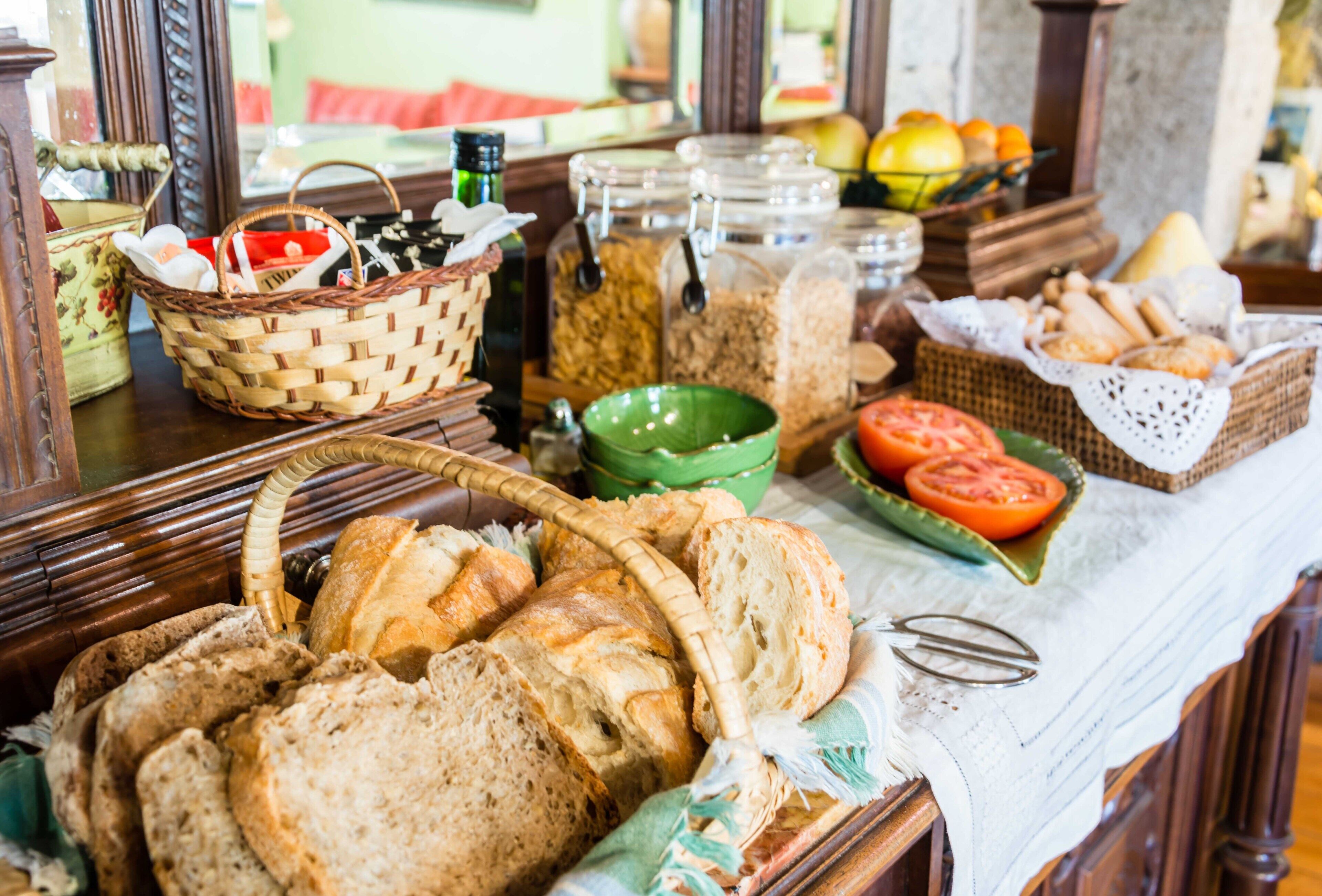 Una mesa de buffet con diversos panes, tomates y frascos de salsas.