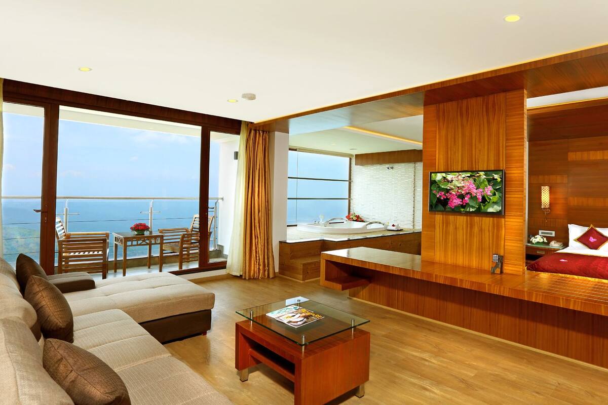 A modern living room with a sofa, coffee table, and a view of the sea.