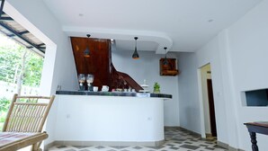 Una cocina con una isla curva, sillas de madera y lámparas colgantes.