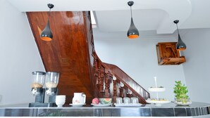 Una cocina con una escalera de madera, una estación de café y una planta pequeña.