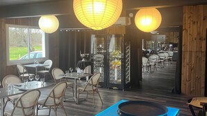 Un restaurante con mesa de billar, sillas y farolillos de papel colgantes.