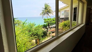 Un balcón con vista al océano y una palmera.