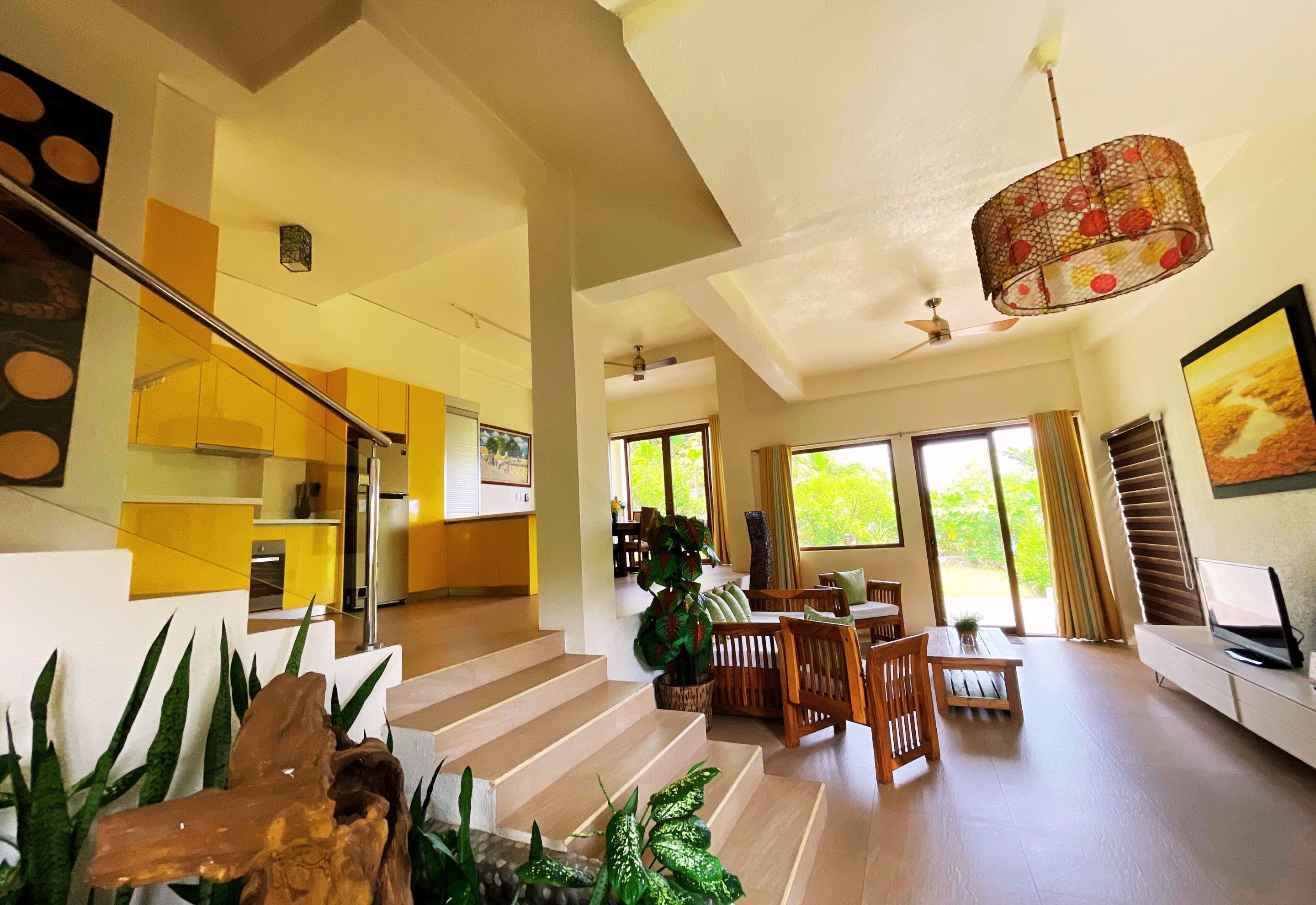 A spacious living area with a staircase, a dining area, and a kitchen.