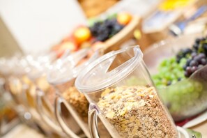 Un bufé con diversos alimentos presentados en recipientes transparentes.