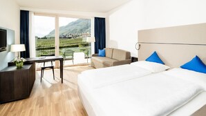 Una habitación de hotel con cama, escritorio, silla y televisión.