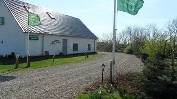 A white building with a gravel driveway and a flag.