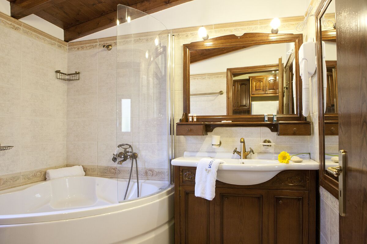 Un baño con bañera, lavabo y espejo.