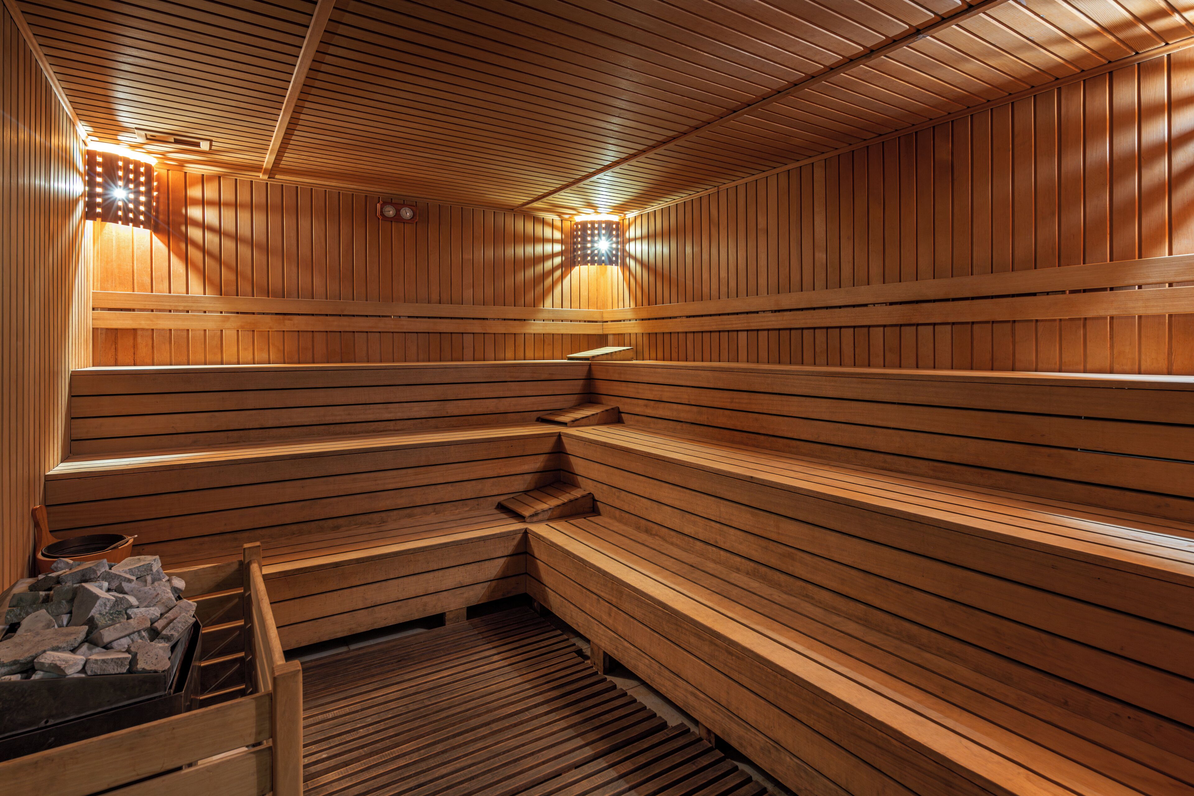 A sauna with wooden benches and a stone basin.