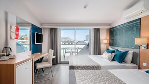 A hotel room with a bed, a desk, a chair, a TV, and a view of the Mediterranean Sea. - Avena Resort & Spa Hotel - All Inclusive  (Alanya)