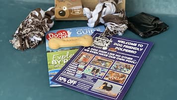 A dog welcome pack from The Claremont Hotel, including a dog toy, a chew toy, a dog food bag, and a brochure.