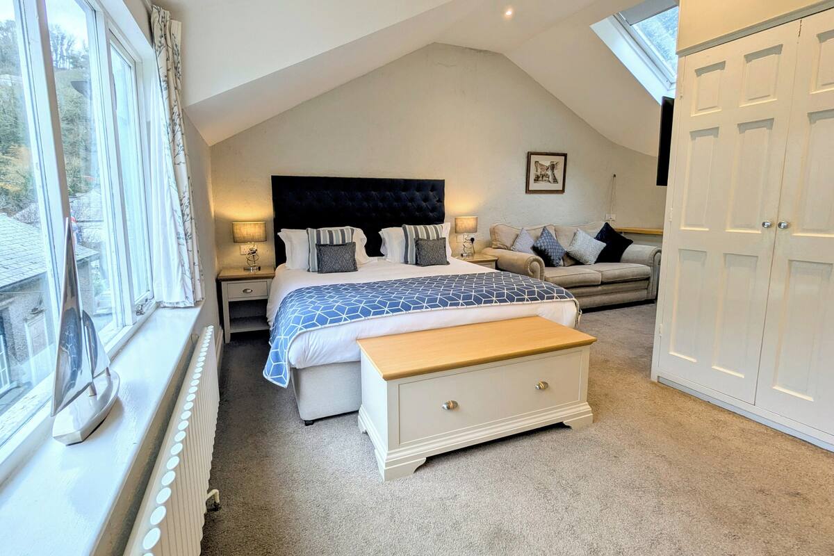 Ein Schlafzimmer mit einem großen Bett, einer Couch, einer Kommode und einem Kleiderschrank.