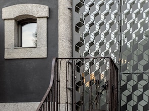 A building facade with a geometric window design and a metal gate. - Malmerendas Boutique Lodging (Porto)