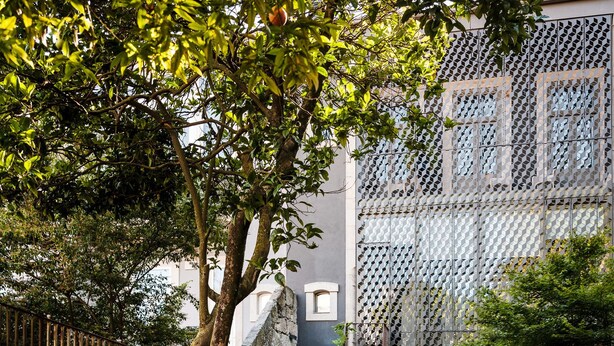 Um pátio com degraus de pedra que levam a um edifício com fachada geométrica.