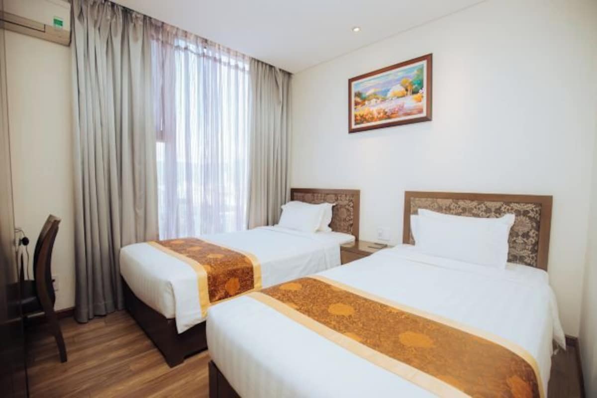 Una habitación de hotel con dos camas, un escritorio y una silla.