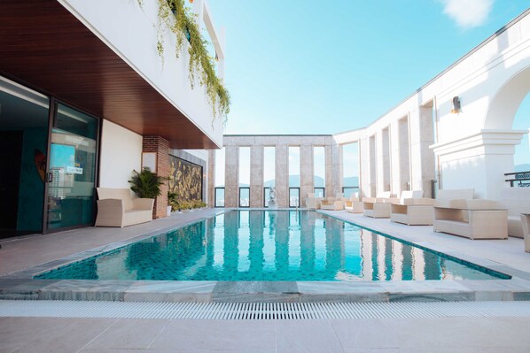 Una piscina al aire libre, tumbonas