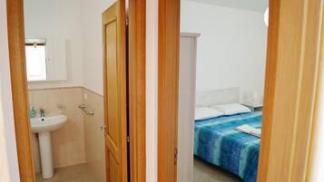 A bedroom with a bed, a bedside table, and a nightstand.