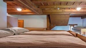 A bedroom with two beds, wooden beams, and a sloped ceiling. - Youth Hostel Brugg (Brugg)