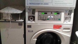 A laundry room with a front-loading washing machine and a dryer stacked on top. - Europa House Village (San Vicente del Raspeig)