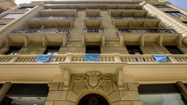 A multi-story building with ornate balconies and a central entrance with a decorative arch. - Pensión Kursaal (San Sebastián)