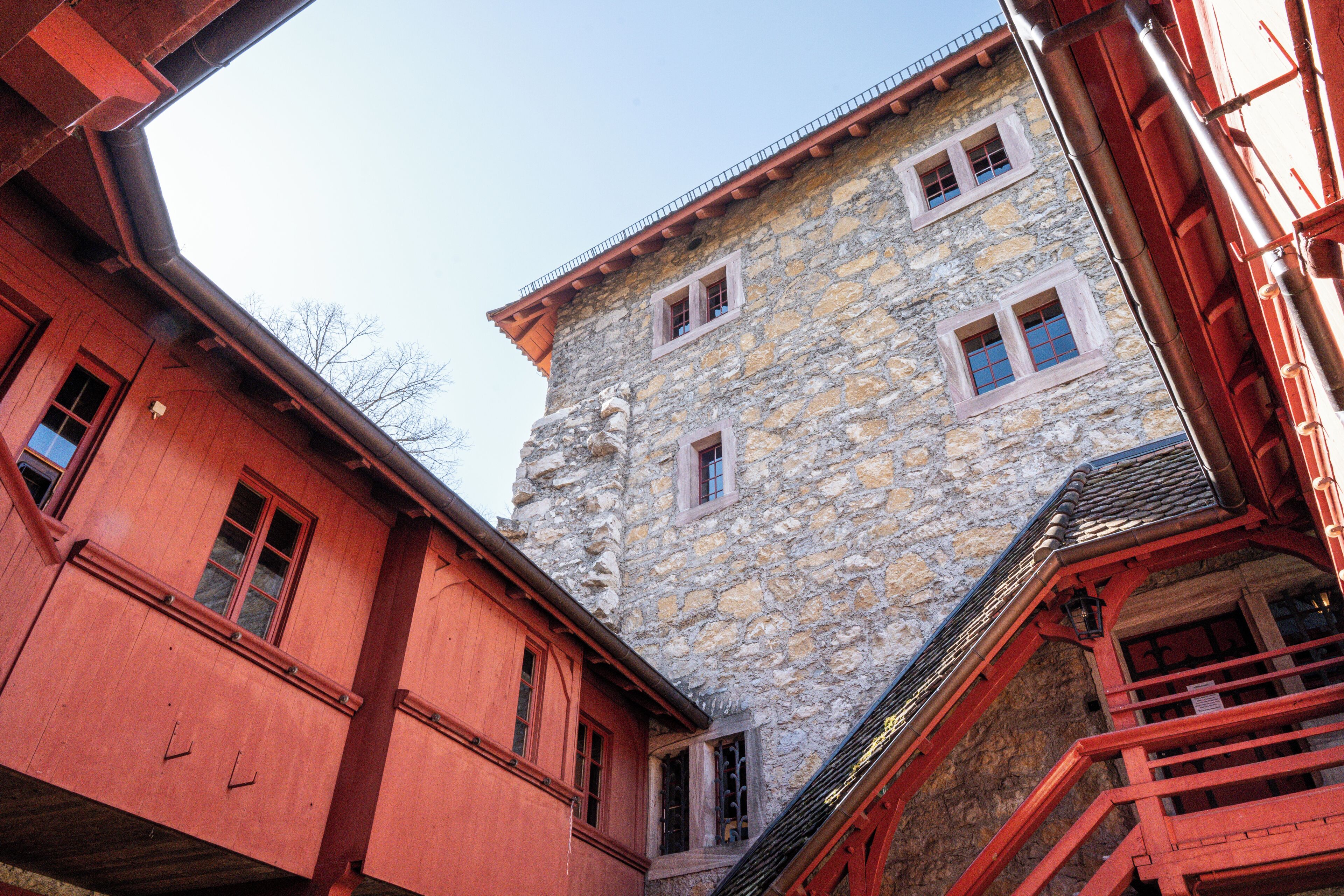 A stone building with multiple windows and a red exterior.