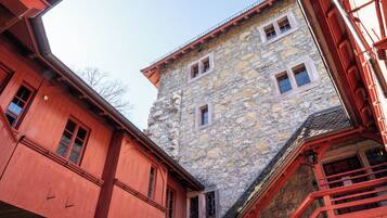 A stone building with multiple windows and a red exterior.