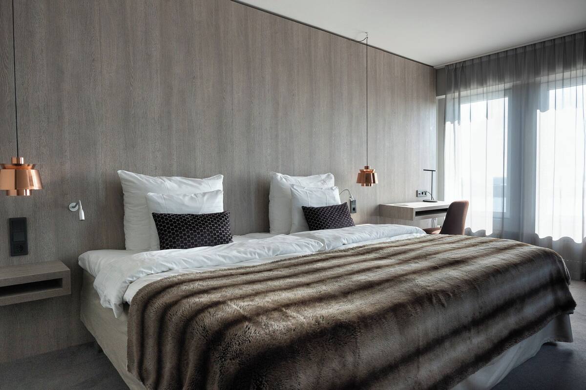 Een moderne hotelkamer met een groot bed, een bureau en een stoel.