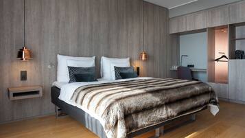 A modern bedroom with a wooden wall, a bed with a striped blanket, bedside lamps, and a built-in wardrobe.
