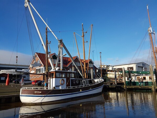 A boat docked at a marina with a building in the background. - Am Lindenhof Bunde (Bunde)