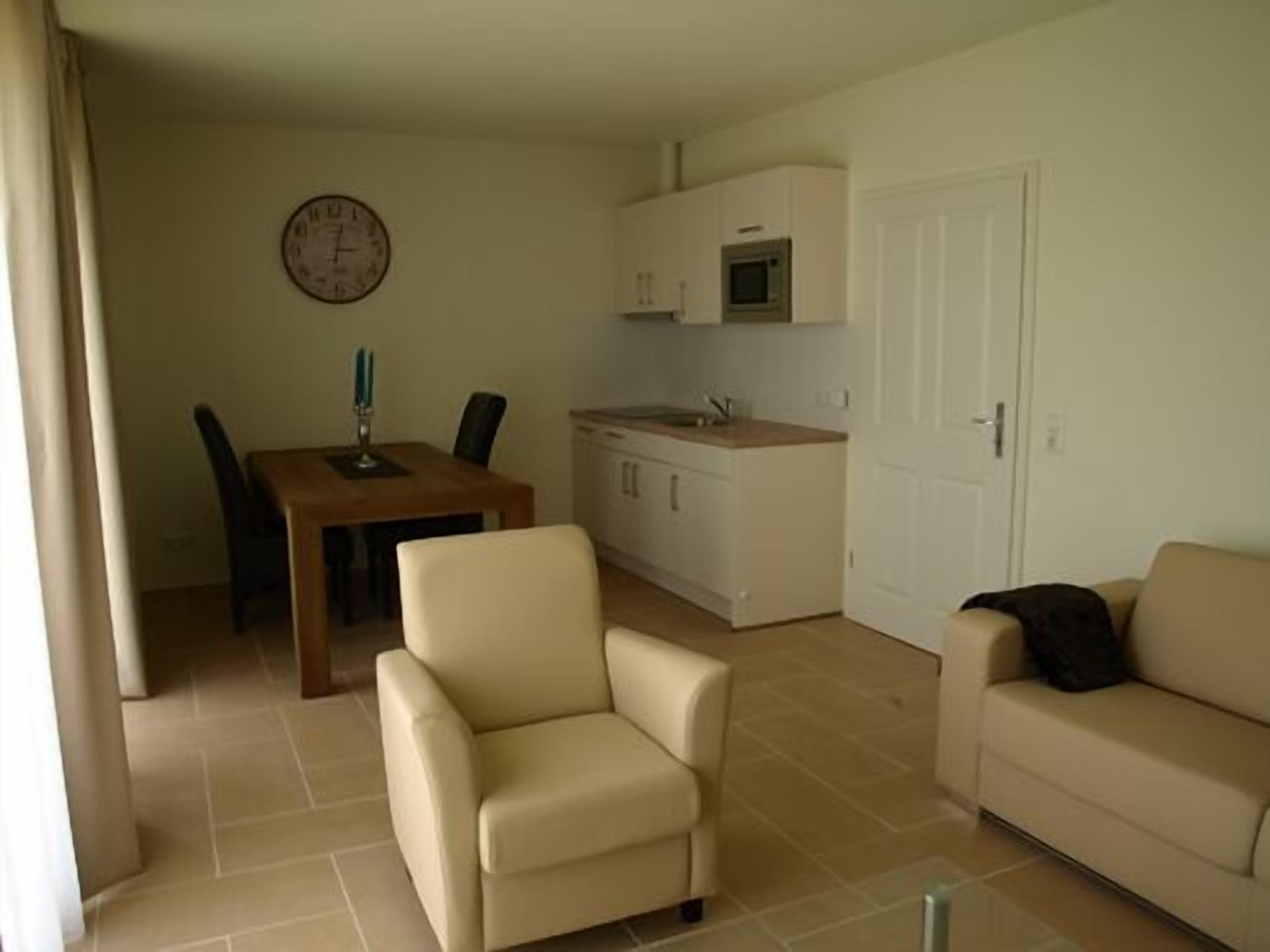 A compact living space with a dining area, kitchenette, and seating area.