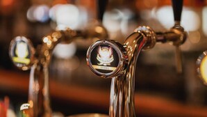 A close-up of a beer tap with a label reading "DUBBEL." - Hotel Corner House (Amsterdam)