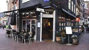 A hotel with outdoor seating and a sign indicating it is a hotel. - Hotel Corner House (Amsterdam)