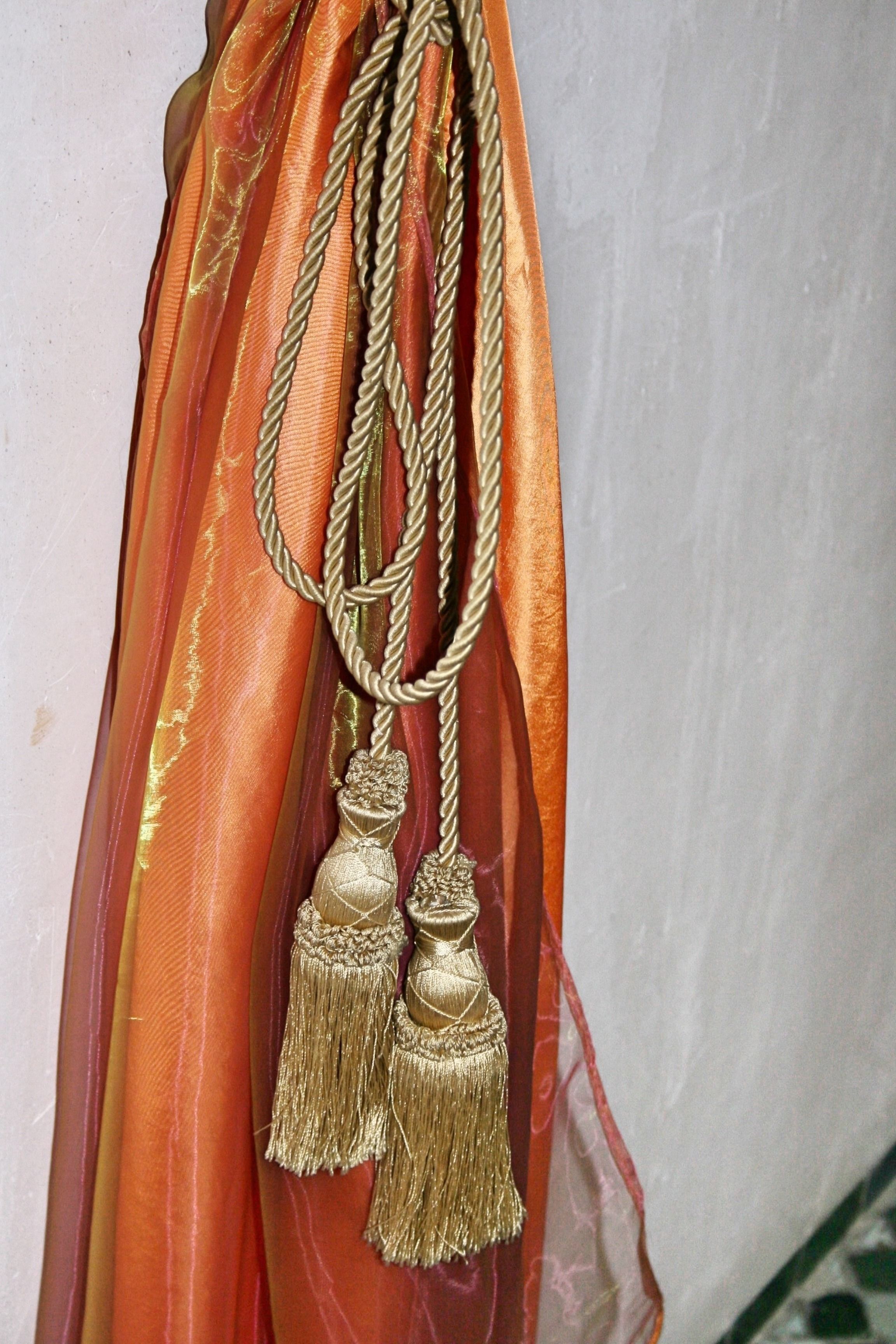 A close-up of a decorative golden tassel hanging from a fabric.