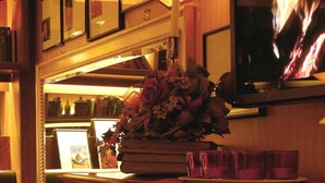 Een piano met bladmuziek, een spiegel en een bloevas.