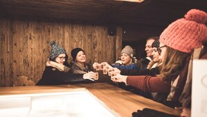 A group of people toasting with drinks at a wooden bar with a rustic interior. - Posthotel Valbella - Berge, Spa & Wir (Vaz-Obervaz)