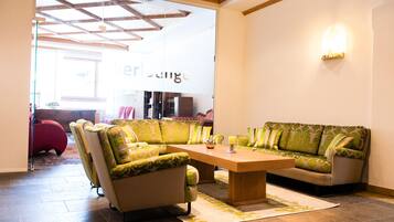 A modern living room with a wooden ceiling, a large sofa set, and a coffee table.