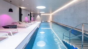 A swimming pool with lounge chairs and a staircase leading to the pool. - Posthotel Valbella - Berge, Spa & Wir (Vaz-Obervaz)