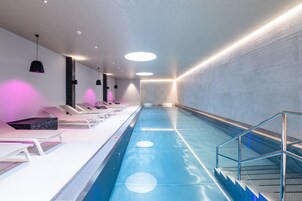 Una piscina techada, sillones reclinables de piscina