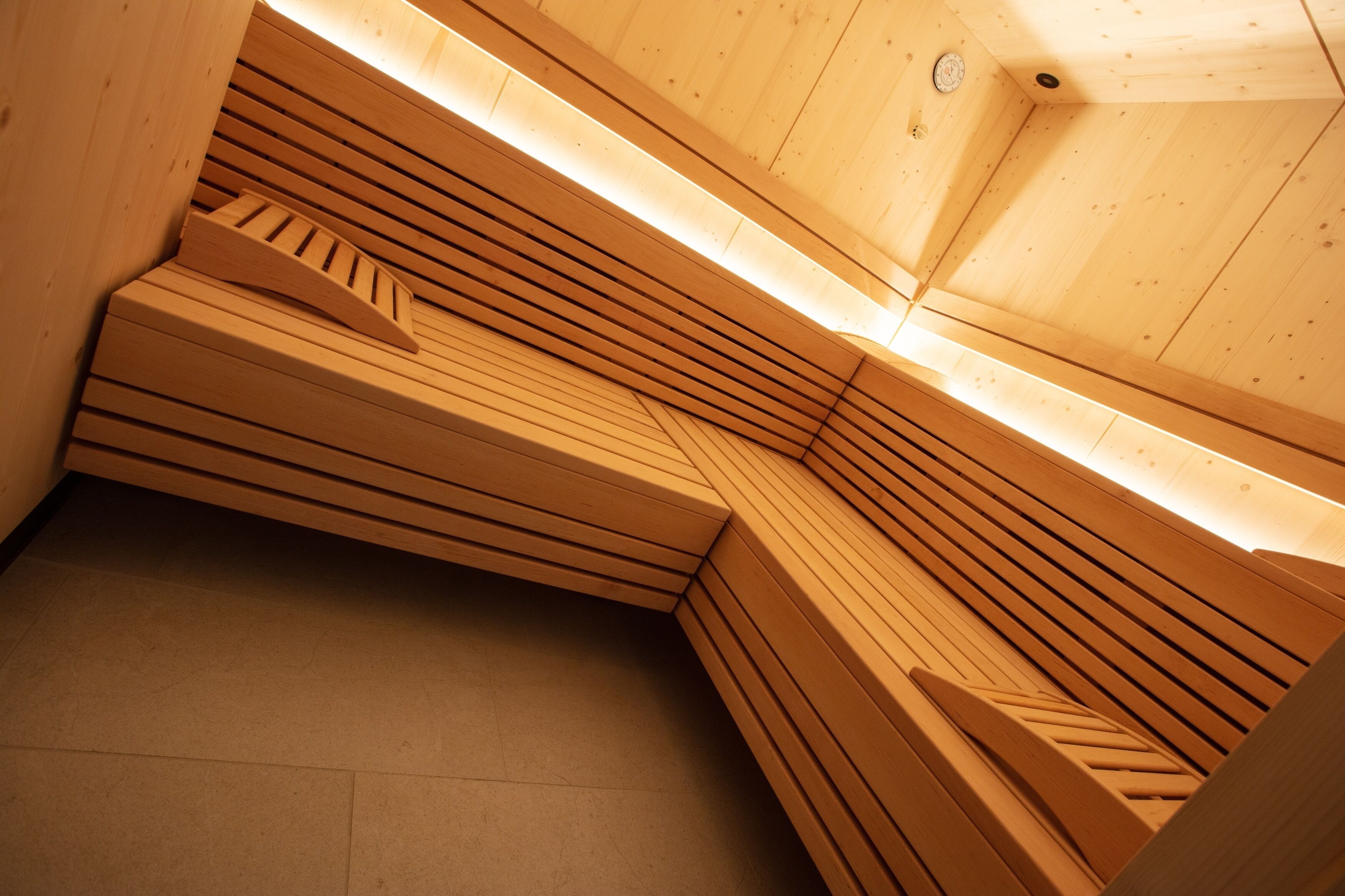 Una sauna de madera con bancos dispuestos en forma curva.